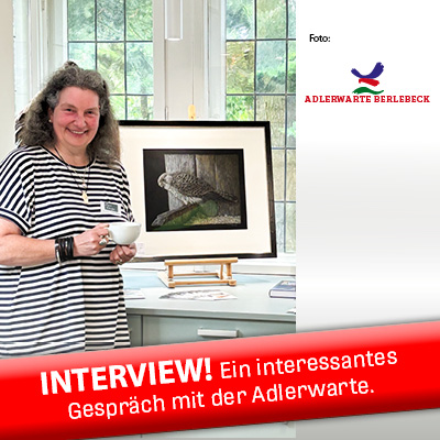 Foto von Susanne vor einem ihrer Bilder. Link zum Interview auf der Website der Adlerwarte.